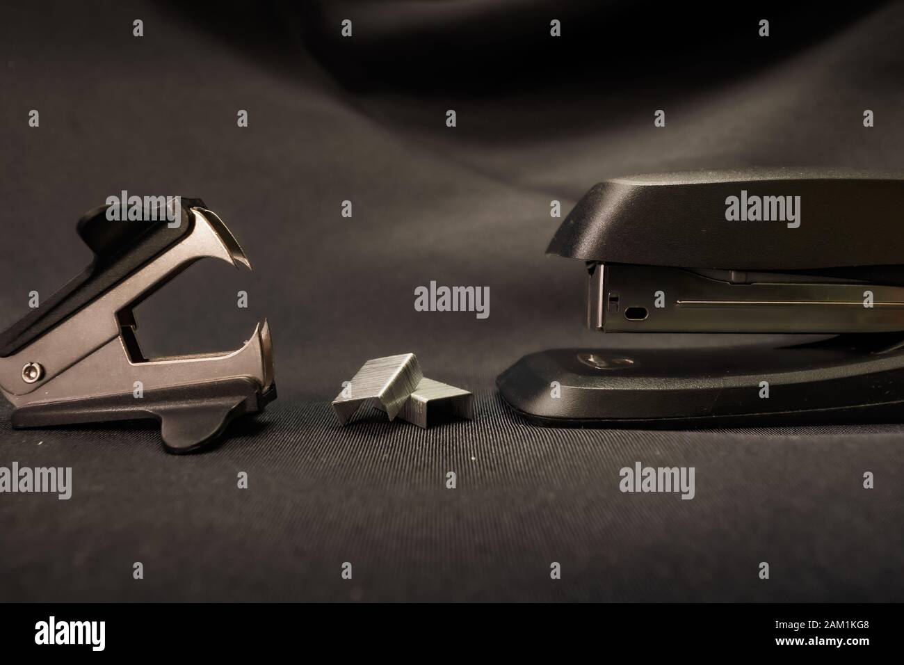 Stapler verses staple remover Office conflict example Stock Photo