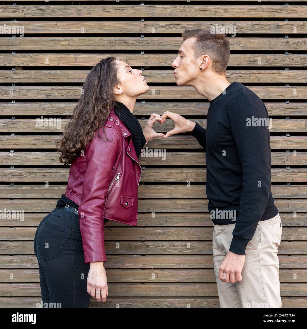 Young couple in love makes the shape of the heart with their hands while they kiss each other's. sweethearts. Love story, Valentine's Day concept Stock Photo