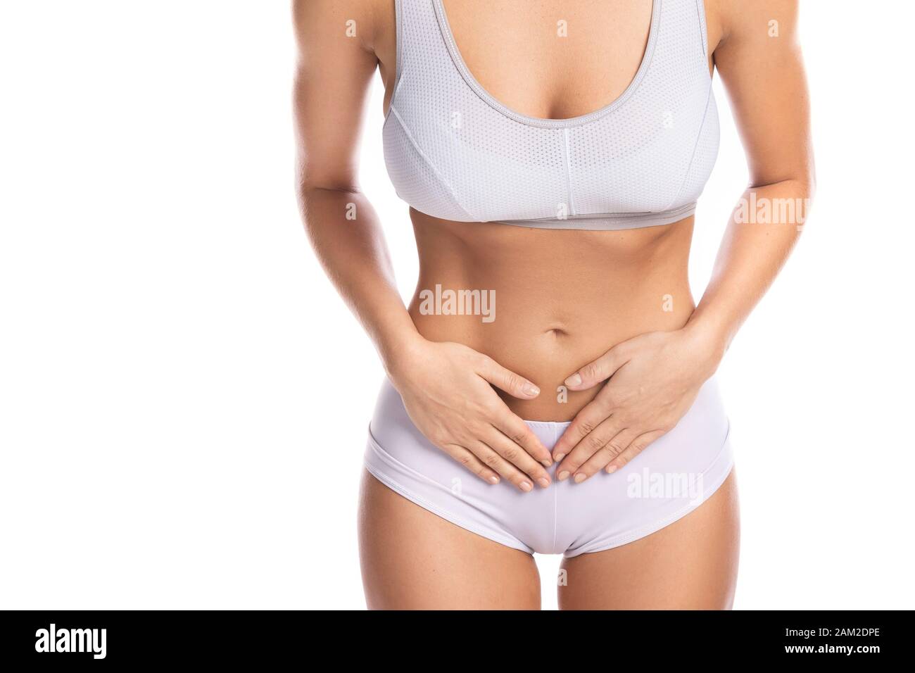 Woman is feeling pain in lower part of her stomach on white background Stock Photo