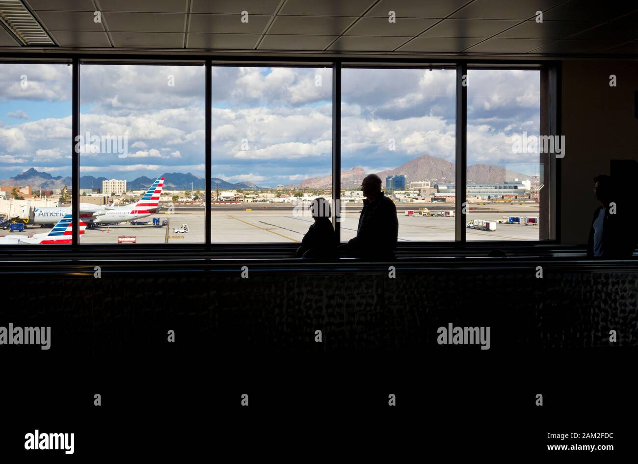 Phoenix Sky Harbor Airport with window views of the planes and tarmac as well as travelers in the airport. Stock Photo