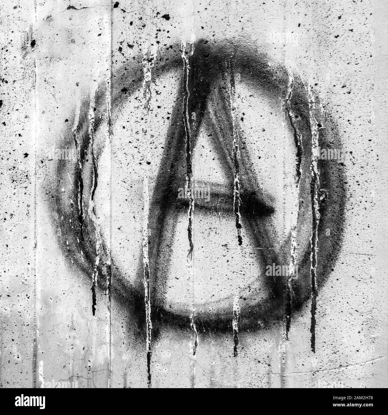 Symbol of Anarchy painted on a grungy concrete wall. Ideal for concepts and backgrounds. Stock Photo