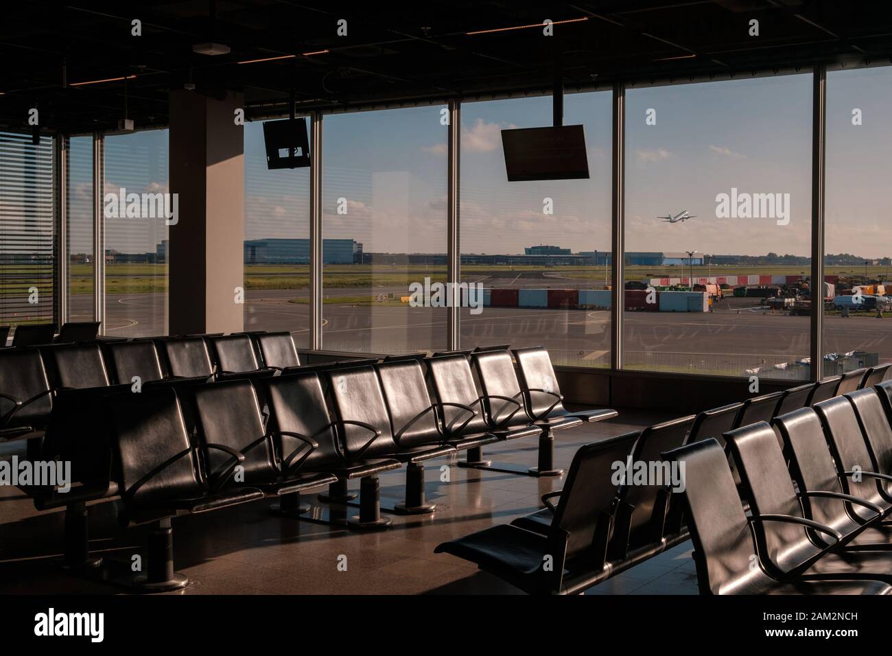 empty airport lounge with runway view windows - Stock Photo