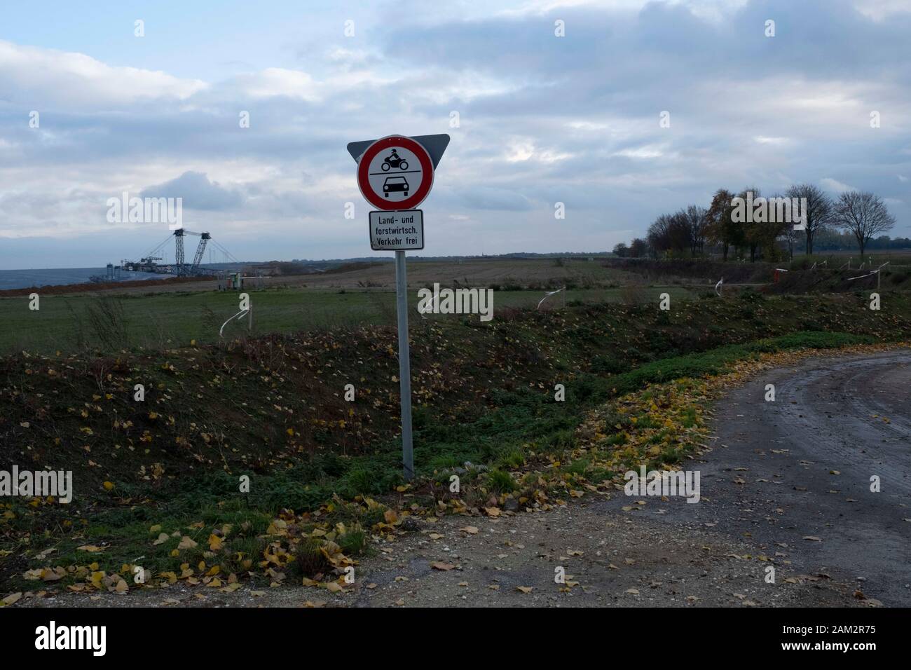 Road sign near open pit coal mine, bucket wheel excavator in background, Garzweiller, Germany Stock Photo