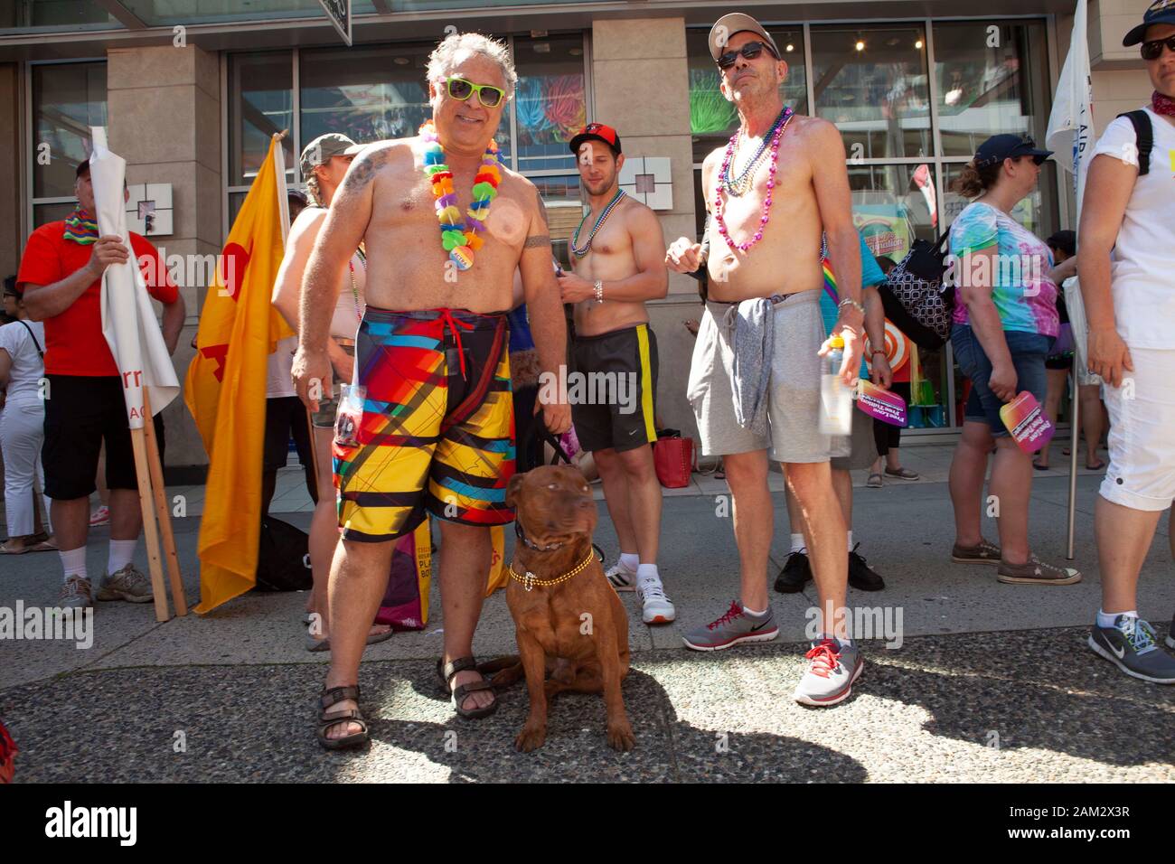 Pride parade participants in shorts posing with pet dog, Vancouver Pride Festival 2014, Vancouver, Canada Stock Photo