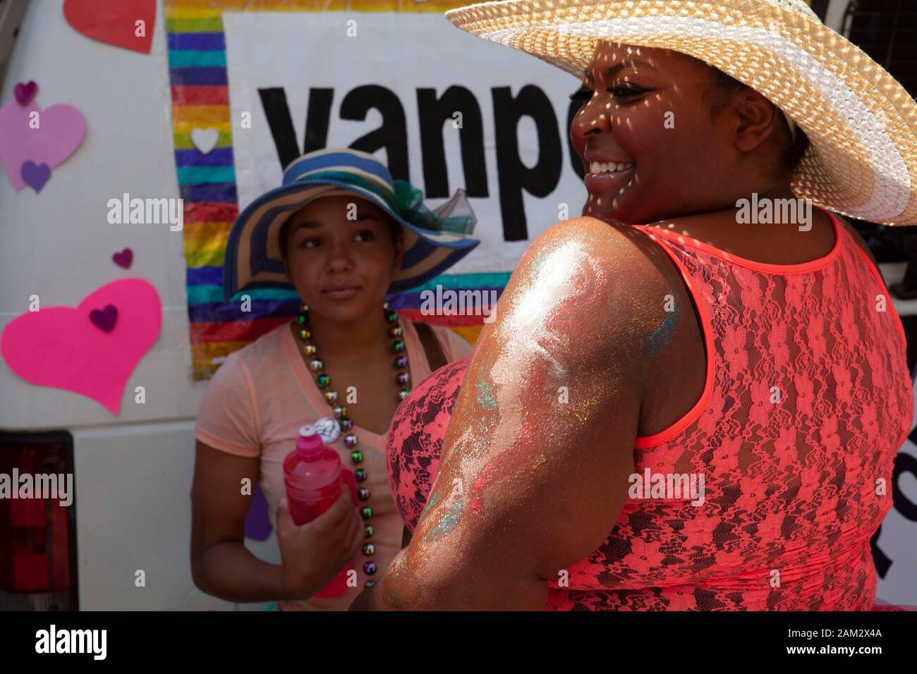Pride parade participant in sun hat looking at friend in lace tank top, Vancouver Pride Festival 2014, Vancouver, Canada Stock Photo