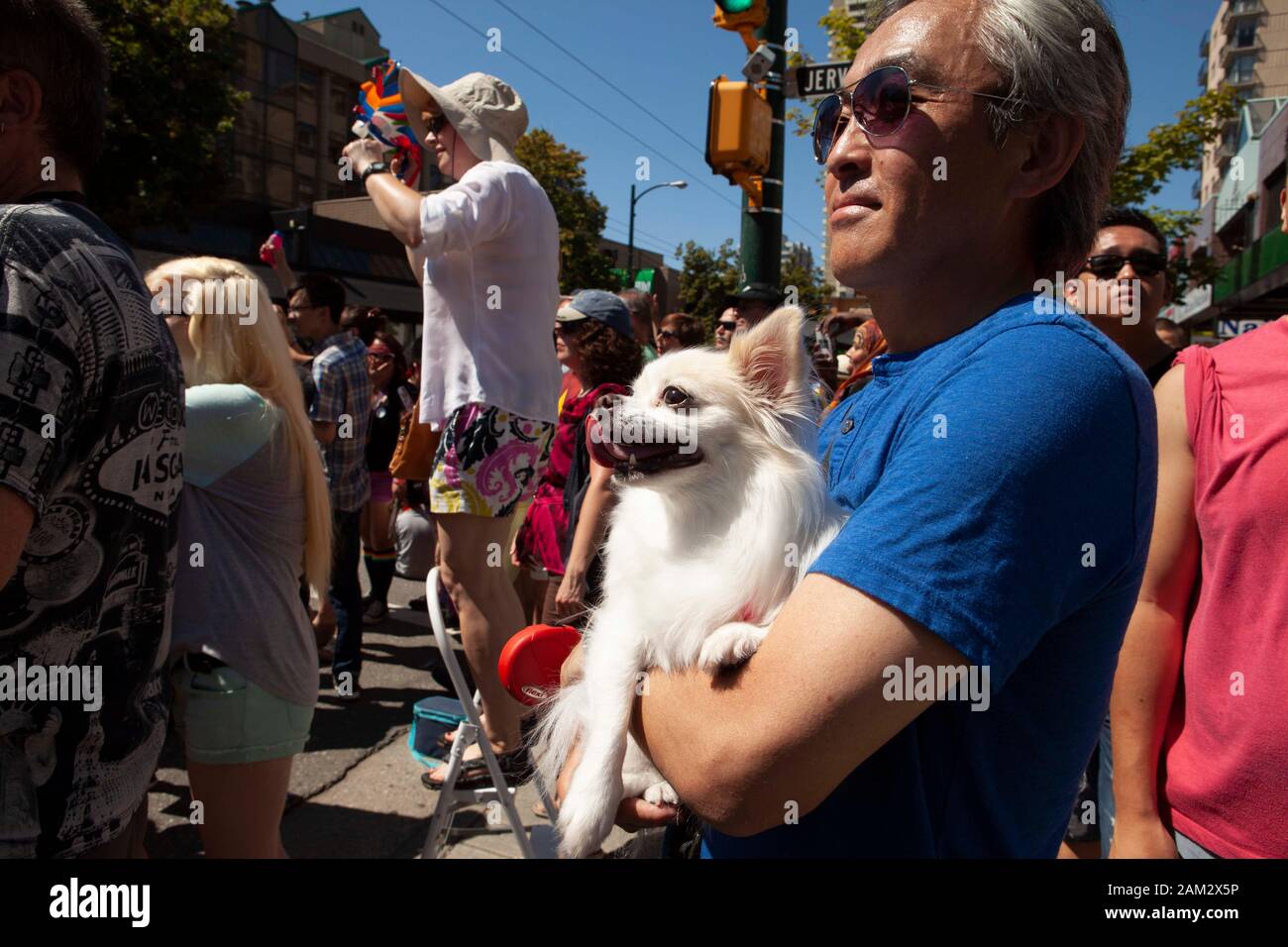 Pride parade spectator carrying pet pomeranian, watching parade, Vancouver Pride Festival 2014, Vancouver, Canada Stock Photo