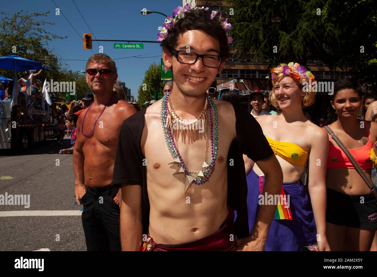 Pride parade participant posing in floral headband in street, crowd in background, Vancouver Pride Festival 2014, Vancouver, Canada Stock Photo