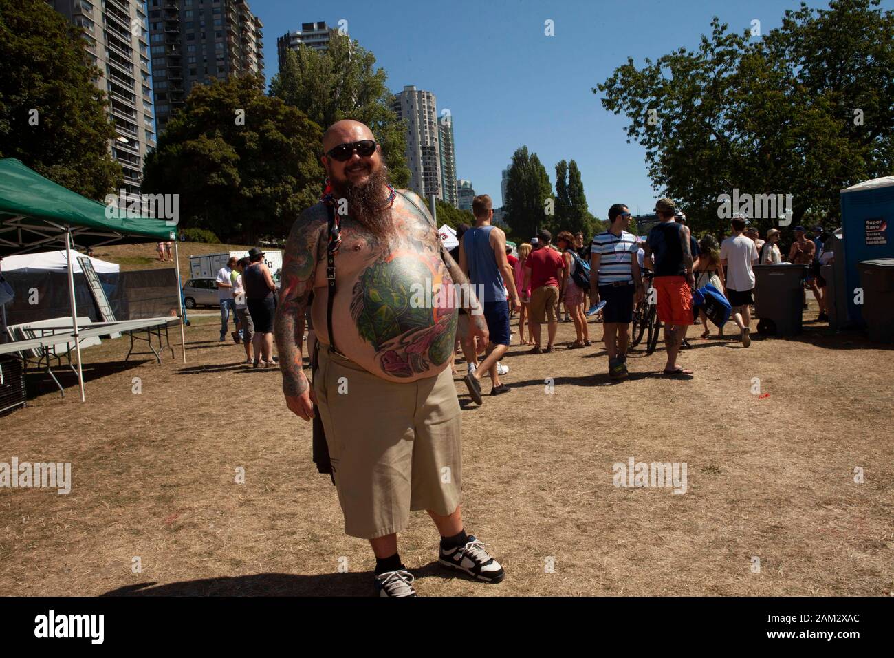 Pride participant showing off full body art, high rise buildings in background, Vancouver Pride Festival 2014, Vancouver, Canada Stock Photo
