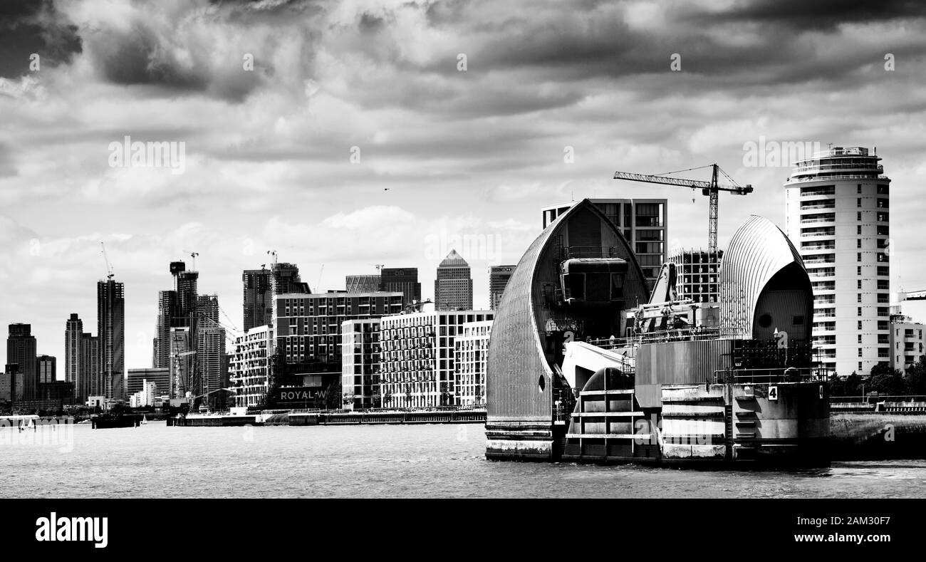 Black White Image Of Thames Barrier London Uk With Canary Wharf