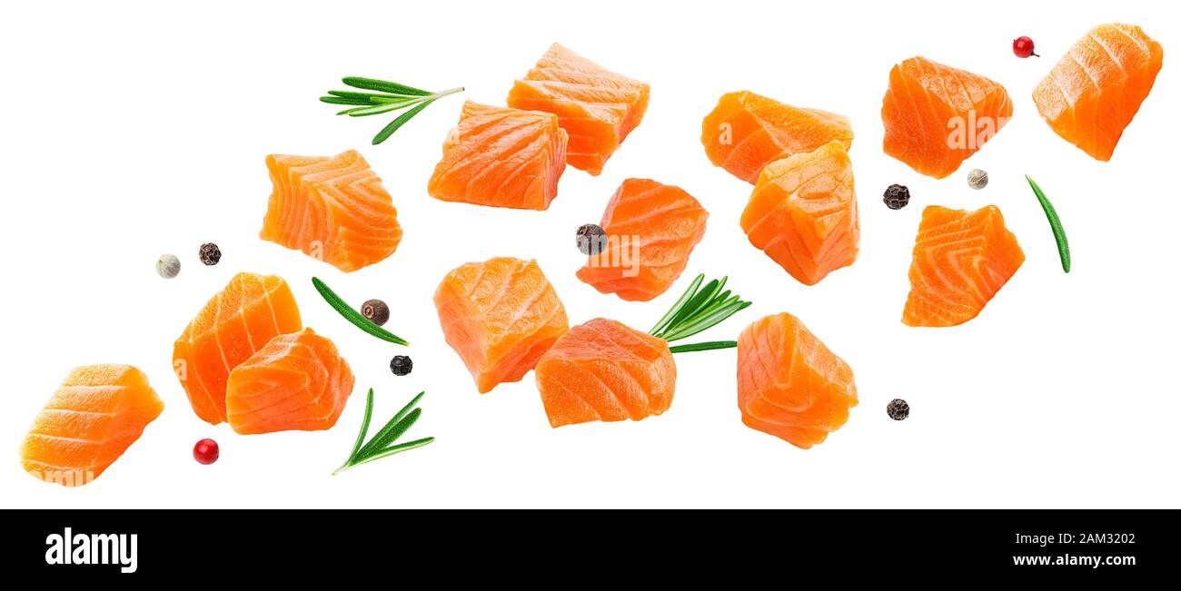 Falling salmon slices isolated on white background with clipping path, cubes of red fish with spices, ingredient for sushi or salad Stock Photo