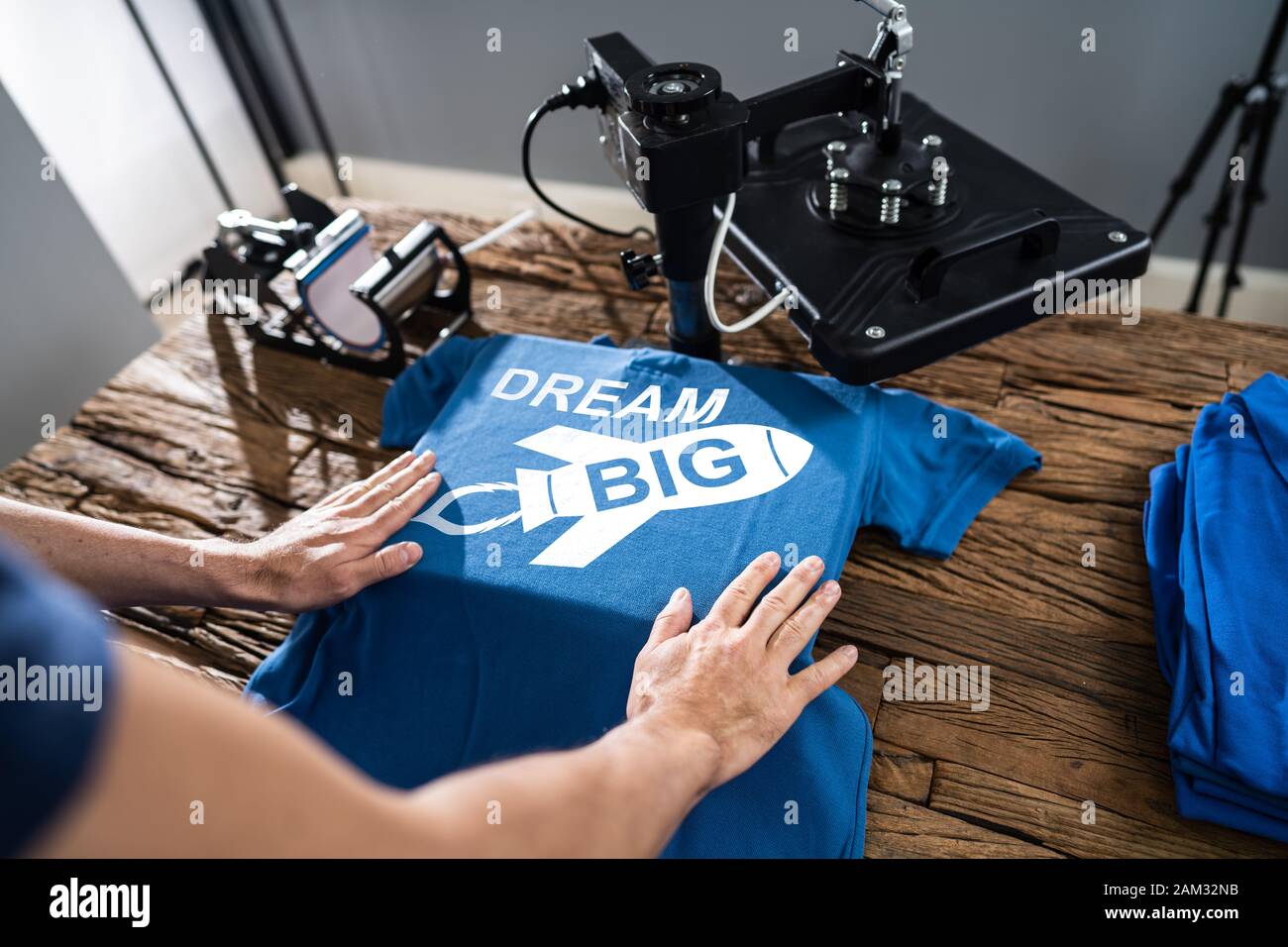 Man Printing On T Shirt In Workshop Stock Photo