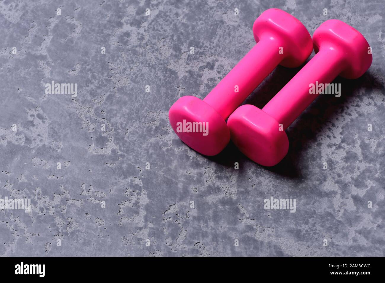 Workout and sport concept. Dumbbells made of bright pink plastic