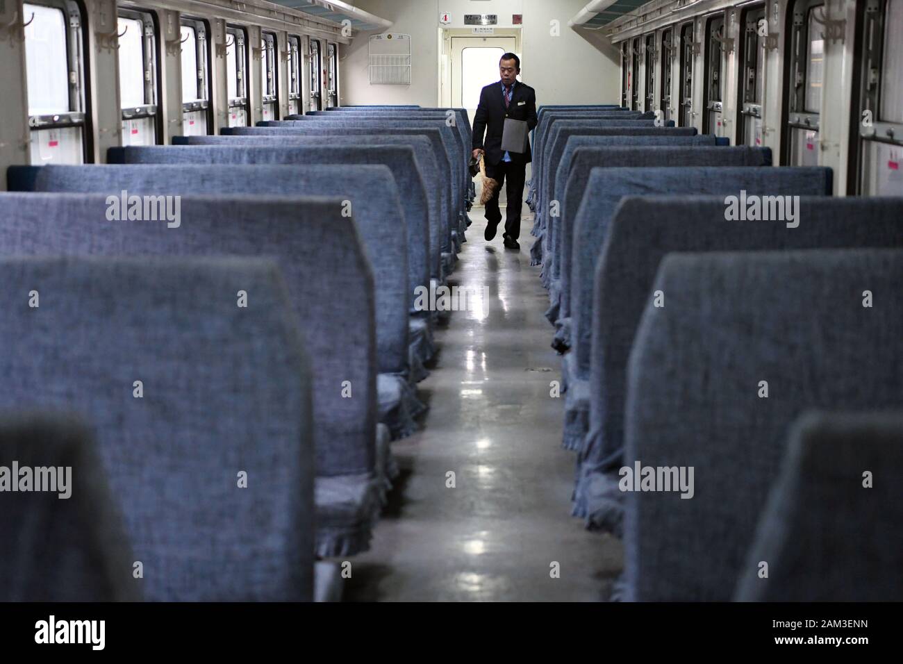 (200111) -- LANZHOU, Jan. 11, 2020 (Xinhua) -- Train conductor Sun Guofan does cleaning on the train No. 7505 at the Lanzhou Railway Station in Lanzhou, capital of northwest China's Gansu Province, Jan. 10, 2020. The train No. 7505, which travels from Lanzhou to Wuwei, is a four-carriage ordinary train. The train, which links more than a dozen small stations between Lanzhou and Wuwei, runs 290 kilometers in 5 hours and 27 minutes. The full fare is 18.5 yuan (about 2.7 U.S. dollars), with the lowest fare being 1 yuan. It has been running for nearly 40 years since the 1980s, carrying nearly 10 m Stock Photo