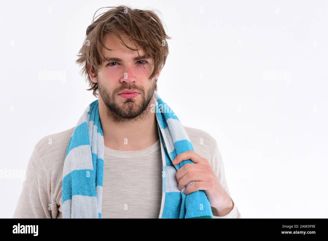 Guy with messy hair isolated on white background, copy space. Man with concentrated face wears striped blue and white towel. Macho with beard after shower. Morning and cleaning concept Stock Photo - Guy with messy hair isolated on white background, copy space. Man with concentrated face wears striped blue and white towel. Macho with beard after shower. Morning and cleaning concept Stock Photo -