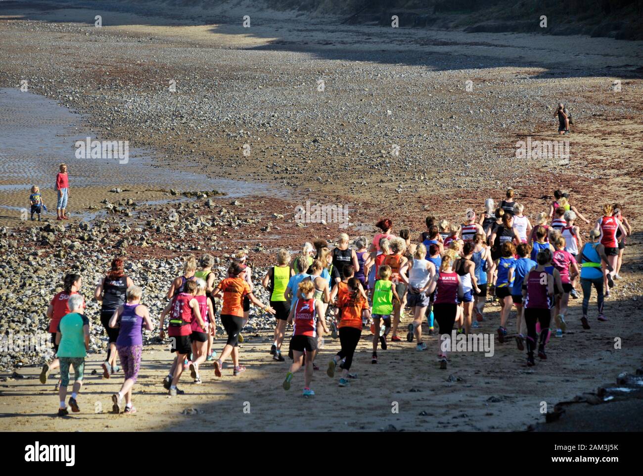 group of women start beach run west runton north norfolk england Stock Photo
