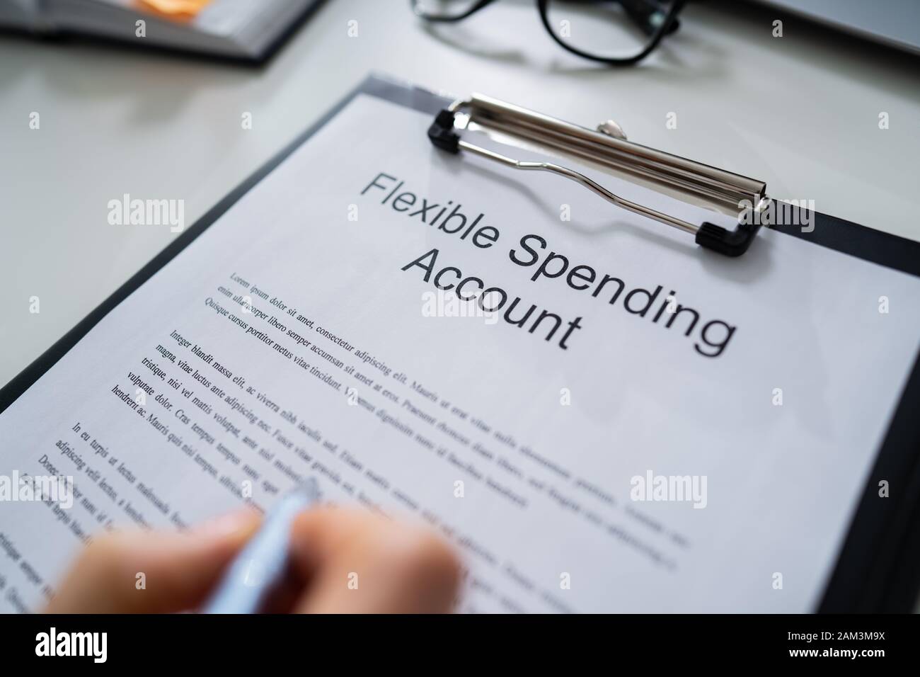 Person Reading Flexing Spending Account Fineprint At Desk Stock Photo