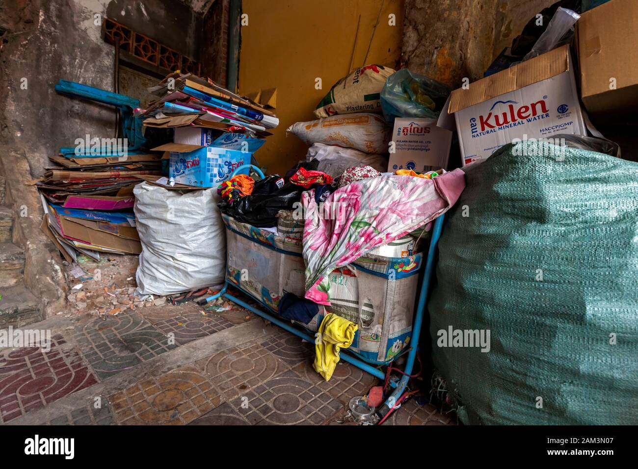 Recyclable material, including cardboard, plastic & aluminum cans sits  in a collection area awaiting transport to a recycler in Kampong Cham Cambodia Stock Photo