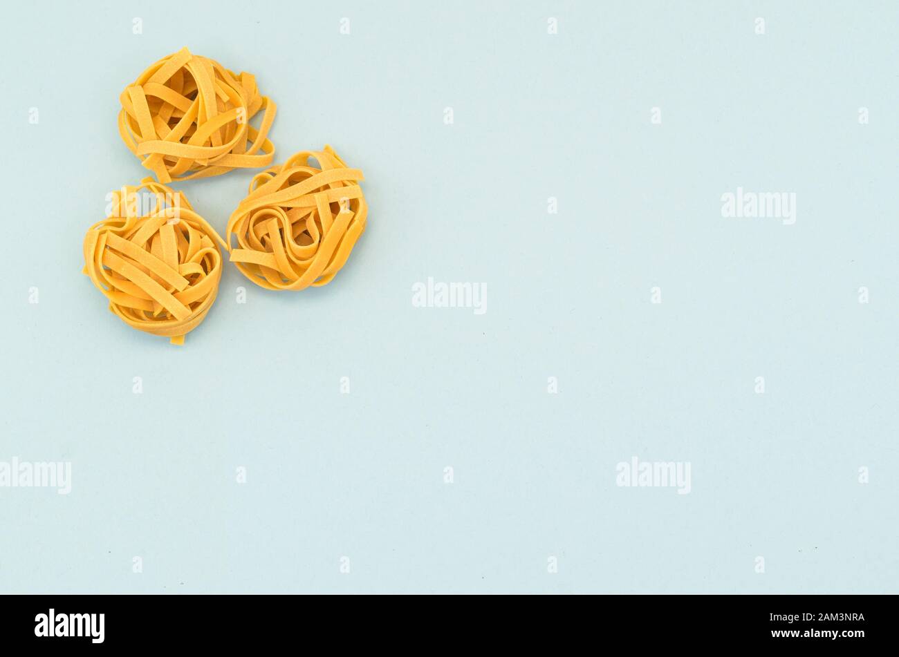 italian tagliatelle nest on a light blue background - natural food ...