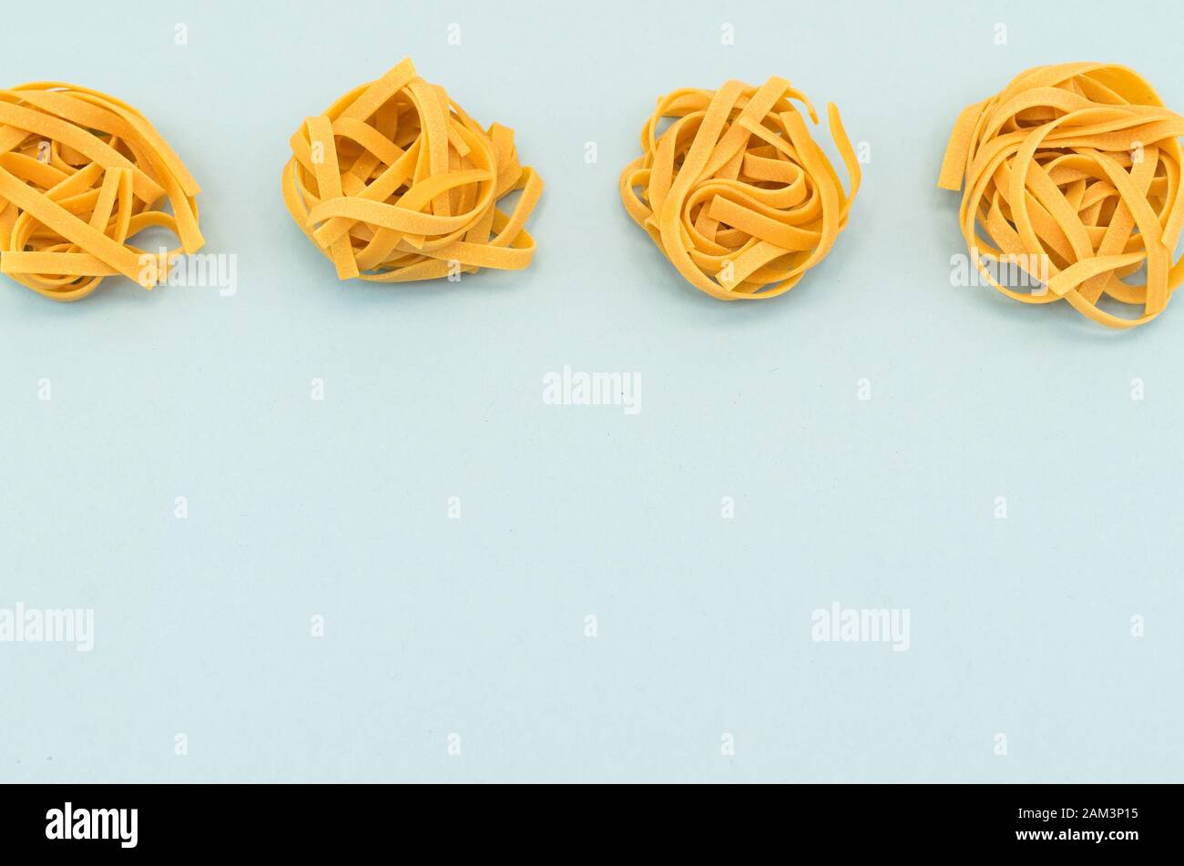 italian tagliatelle nest on a light blue background - natural food ...