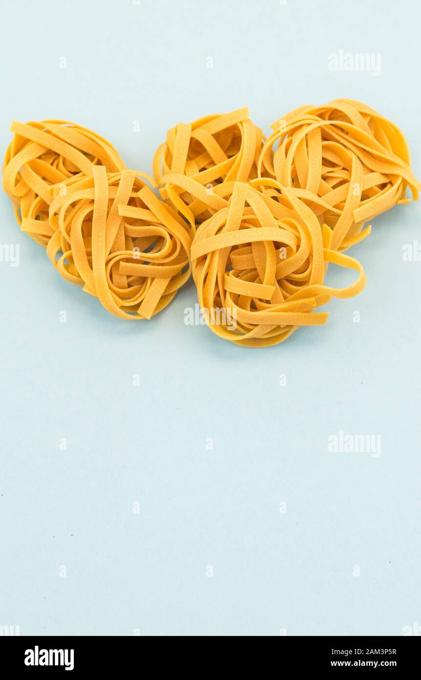 italian tagliatelle nest on a light blue background - natural food ...