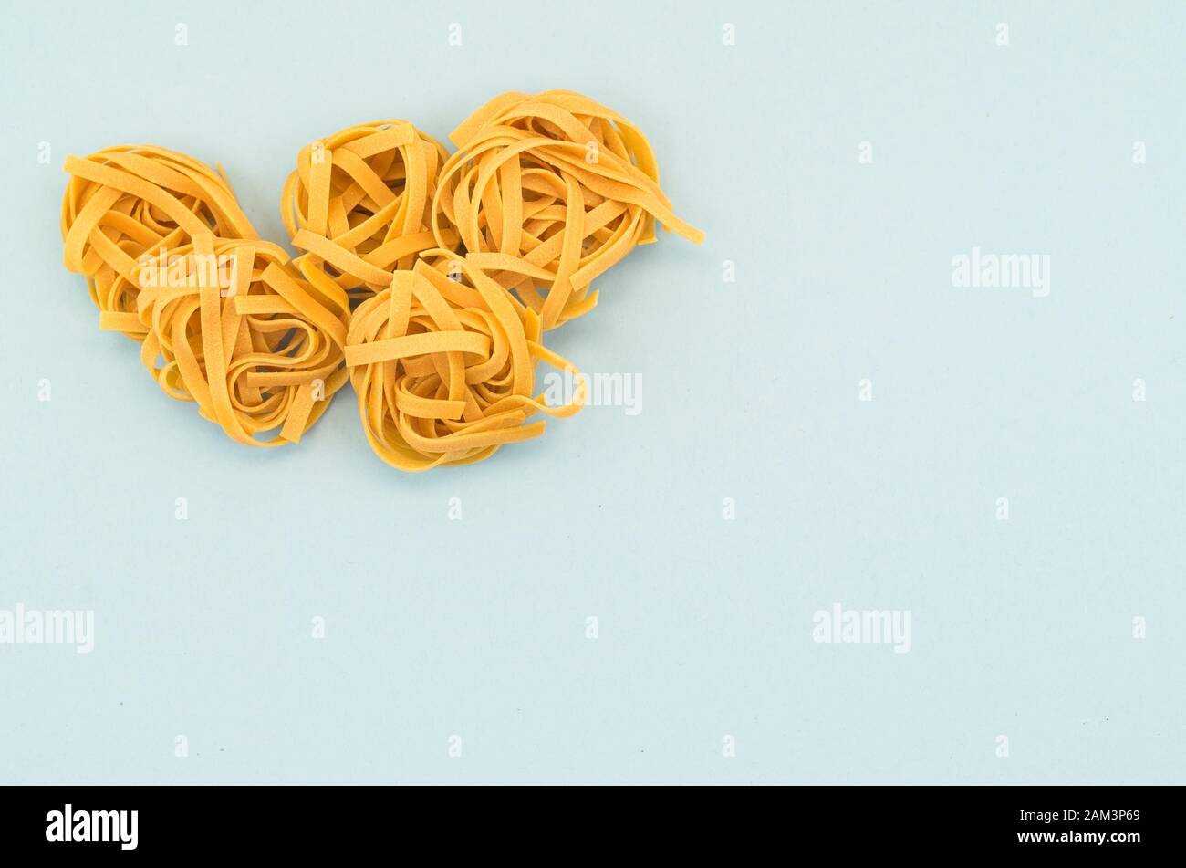 italian tagliatelle nest on a light blue background - natural food ...