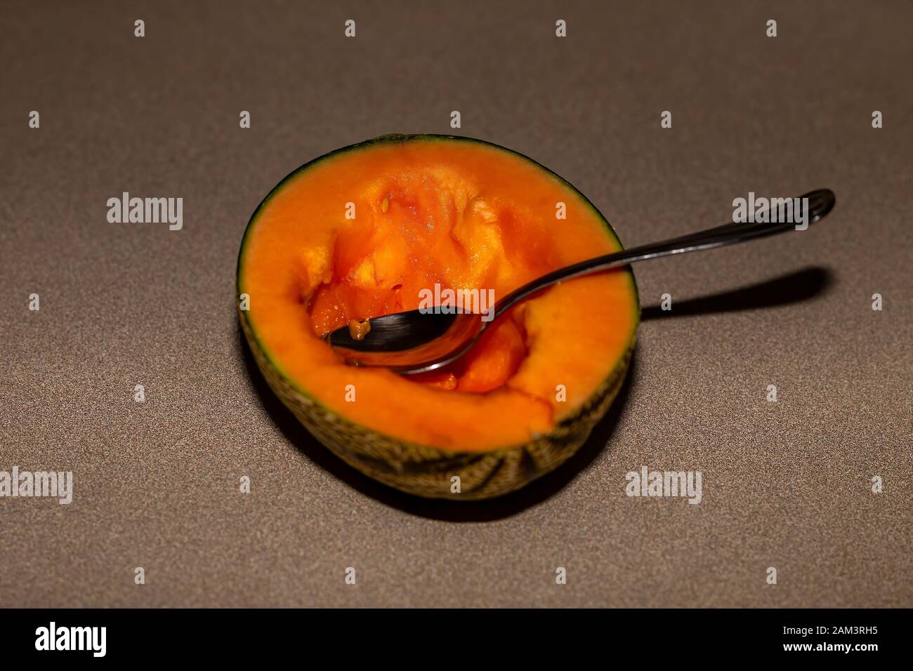 Half of North American Charentais melon with dining spoon.Charentais