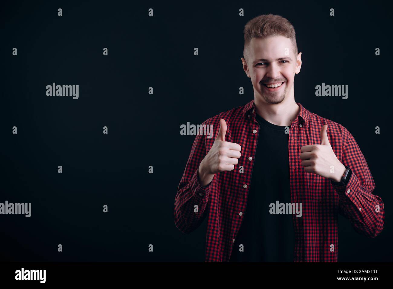 Smiling Young Man with Beard Shows Thumbs Up Stock Photo