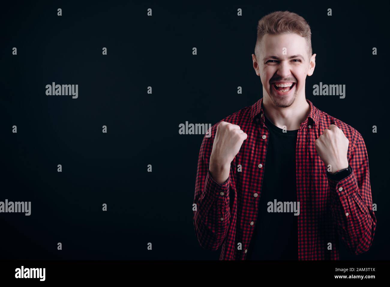 Young Man Shows Success Emotions, His Fists Clenched Stock Photo