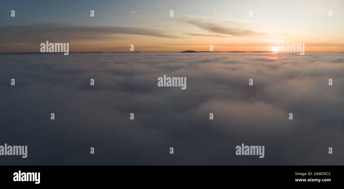 Beautiful panoramic sunrise above clouds from airplane perspective. Stock Photo