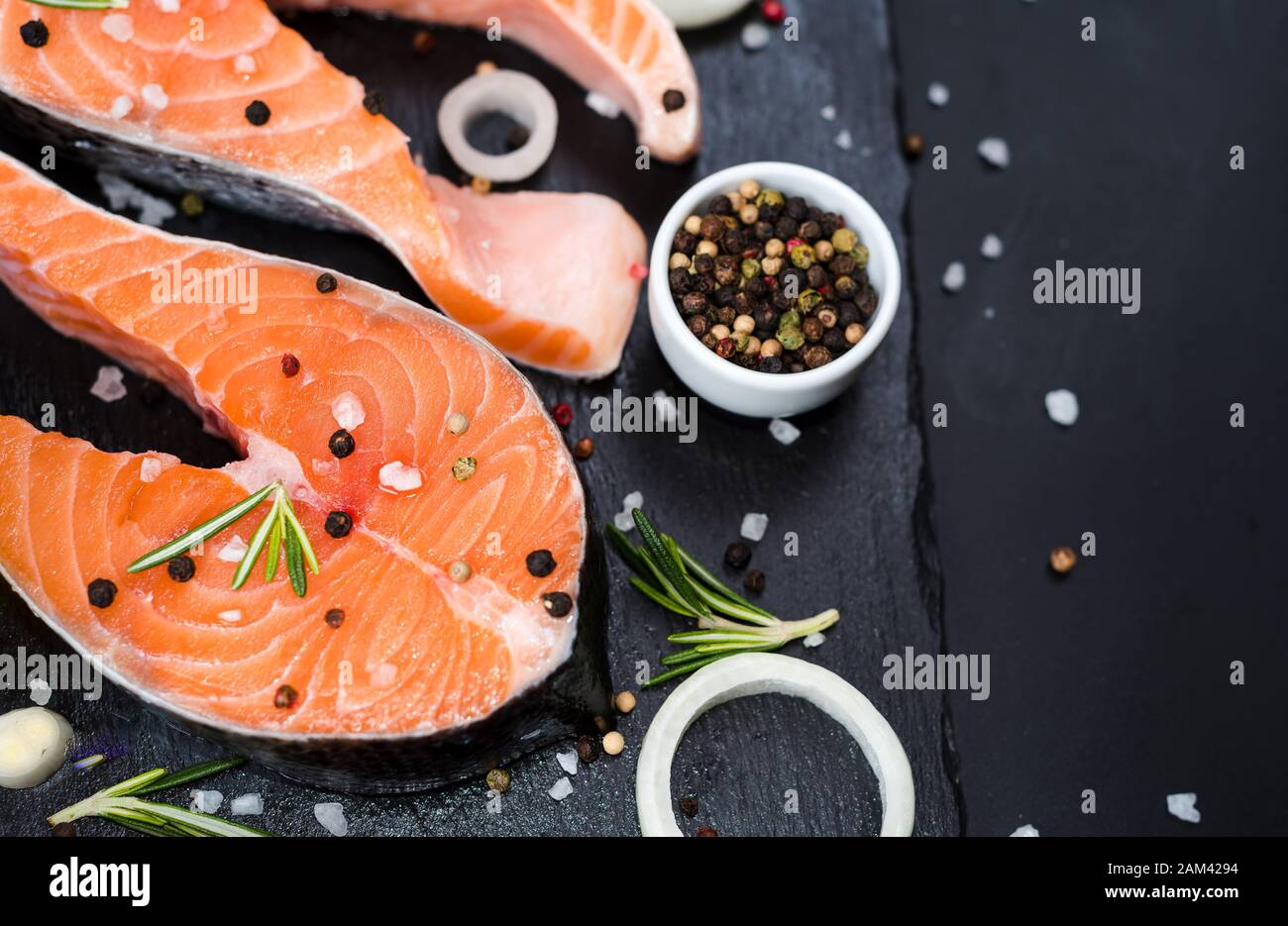 Raw salmon fish steaks with fresh herbs on cutting board Stock Photo ...