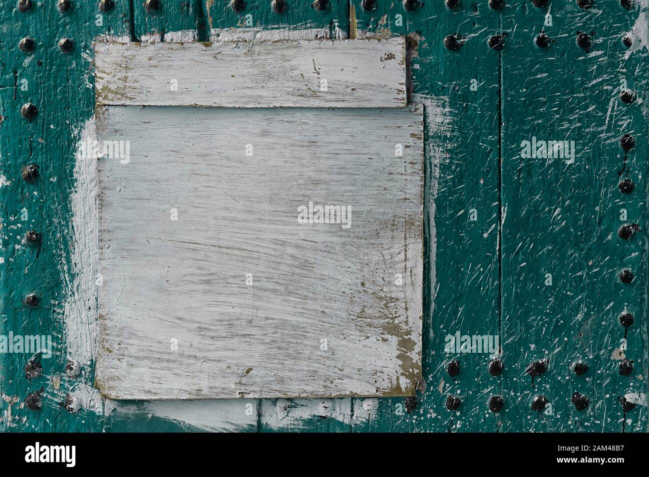 Abstract, detail of an old, mint green, wooden door with a white painted board. Texture background image with copy space. Stock Photo