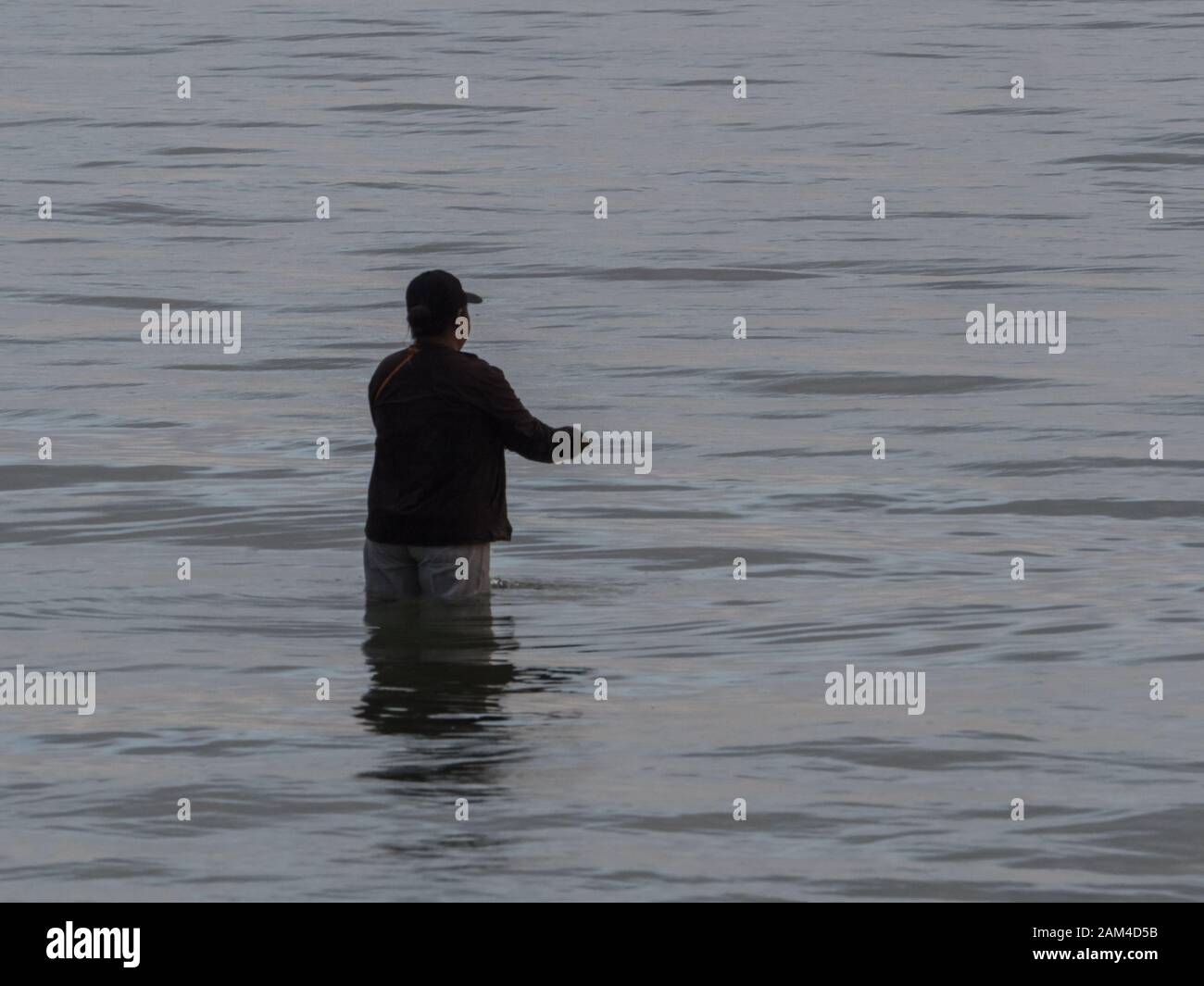 Silhouette of fisherman during high tide on the Saram Sea. Kaimana, Bird's Head Peninsula, West Papua, Indonesia, Asia. Stock Photo