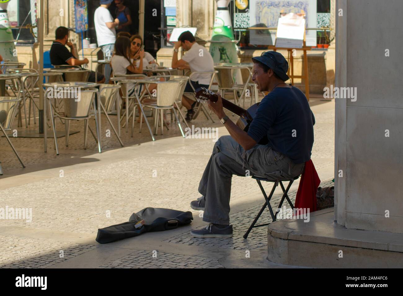 Man busking with a guitar in Rua Visconde da Luz in Coimbra Portugal Stock Photo