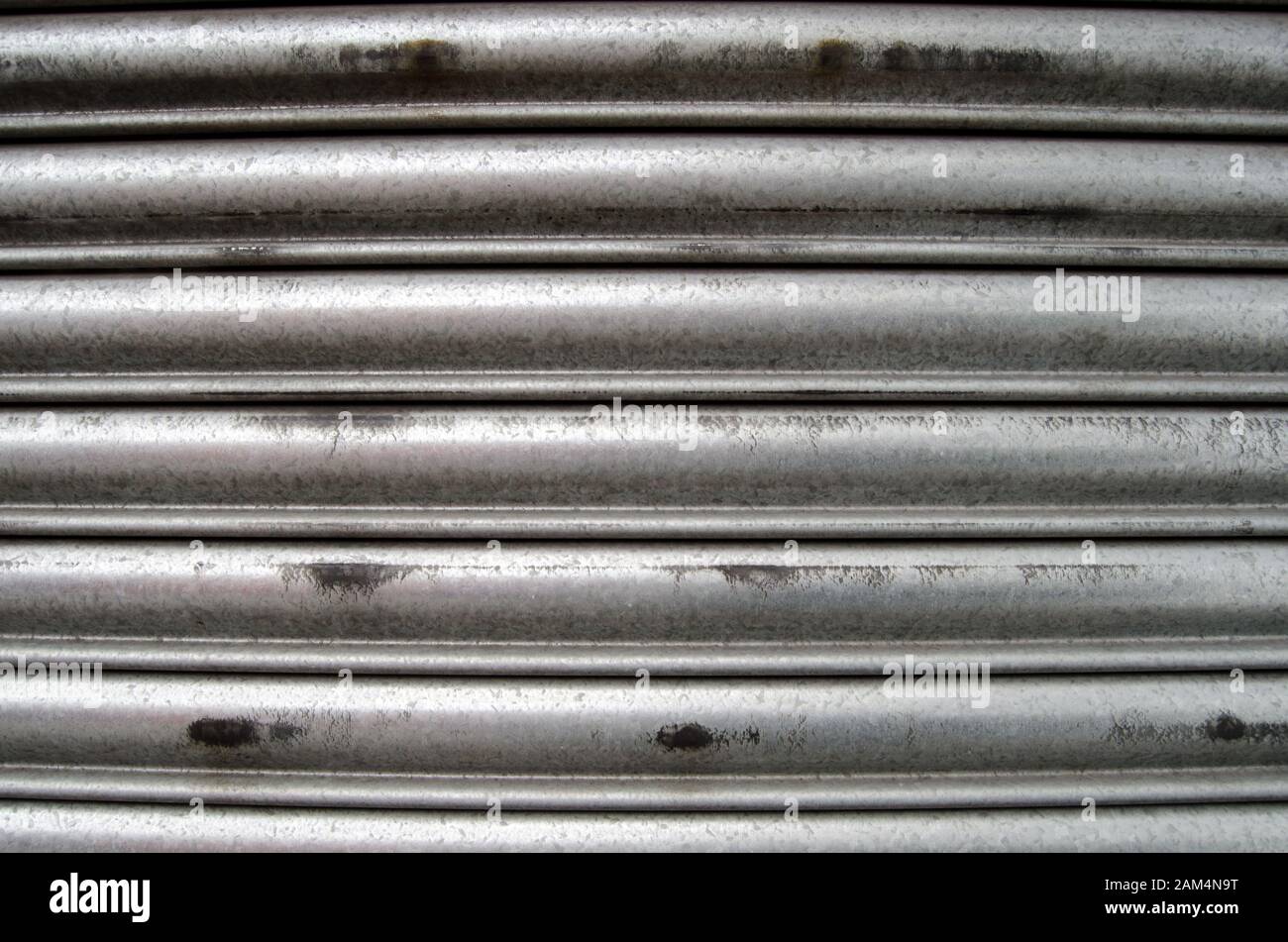 Detail of a closed metal security shutter.  Suitable for use as grunge background or wallpaper. Stock Photo