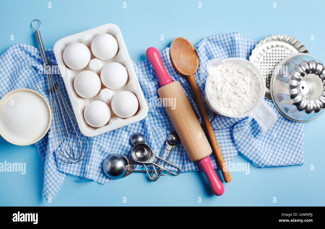 Preparation for baking. Ingredients and kitchen items for baking. Kitchen utensils, flour, eggs, sugar. Top view. Stock Photo