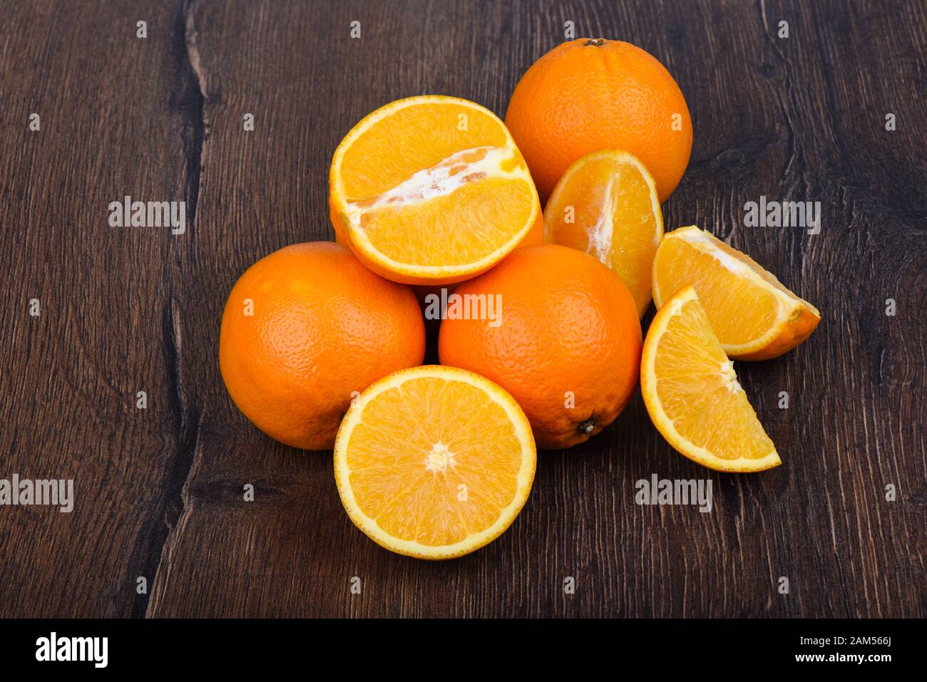 Oranges, whole and slices, on a wooden table. Prevention against colds