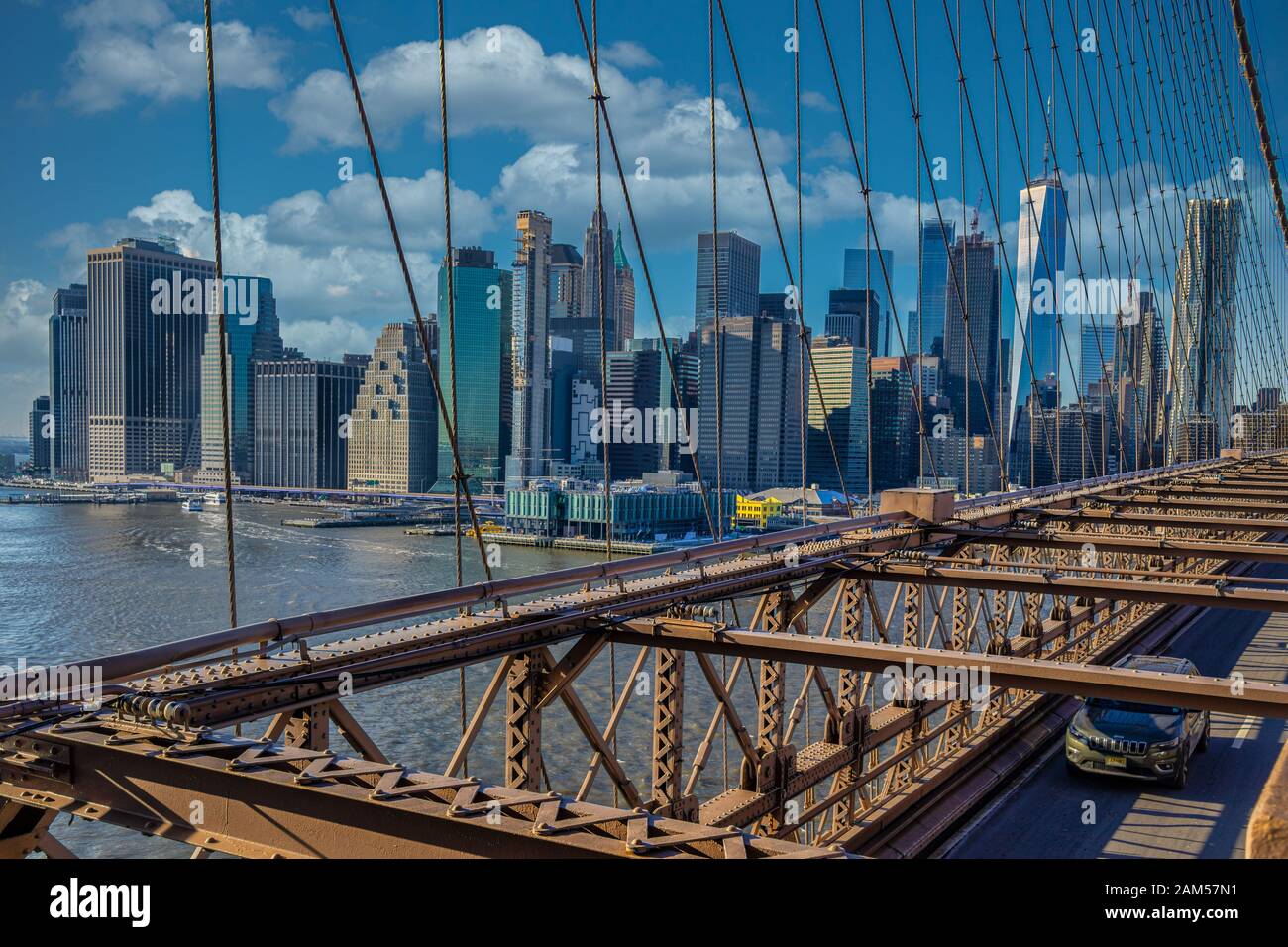 New York skyline from Brooklyn Bridge with clouds in sky in background ...