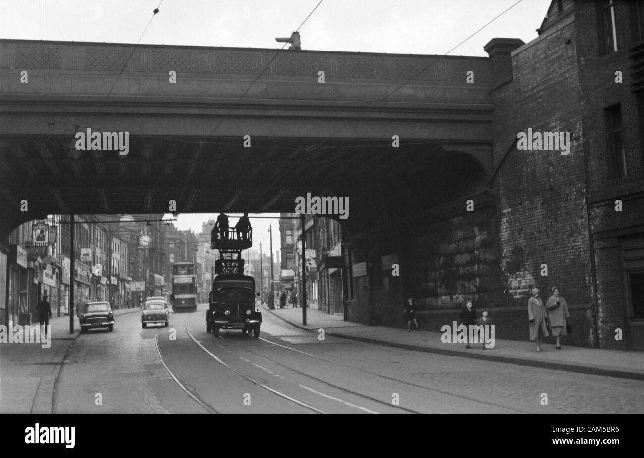 A Bedford Tower Wagon and maintenance team doing running repairs on the tram cables under the railway bridge HUL4/53 and next to the Viaduct pub, 11 Briggate City Centre, Leeds LS1 6ER. Image taken during the late 1950s before the decommissioning of the Tramway Network. The area nowadays is known as the Leeds village and popular with the LGBT community. The railway bridge was painted in the Pride colours in 2017 and also known as the Leeds Freedom Bridge. Stock Photo