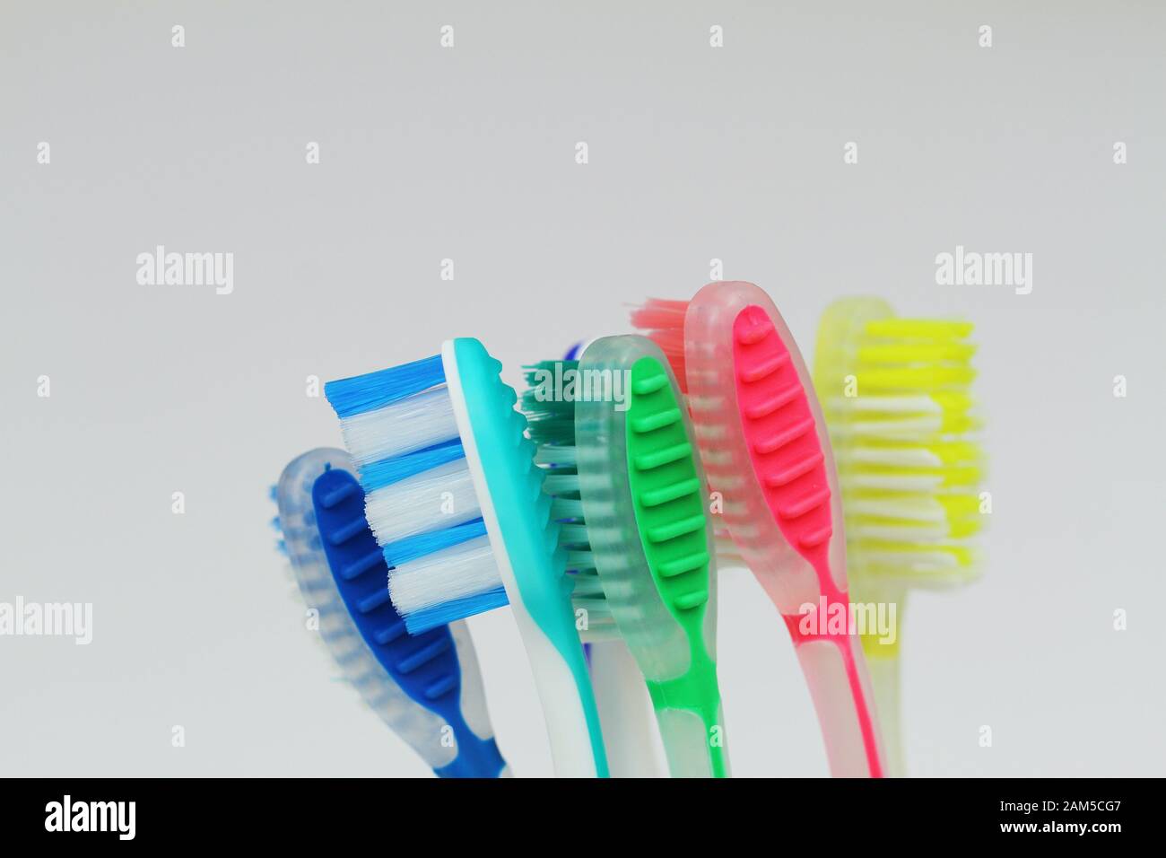 Closeup of few colorful toothbrushes on white background Stock Photo