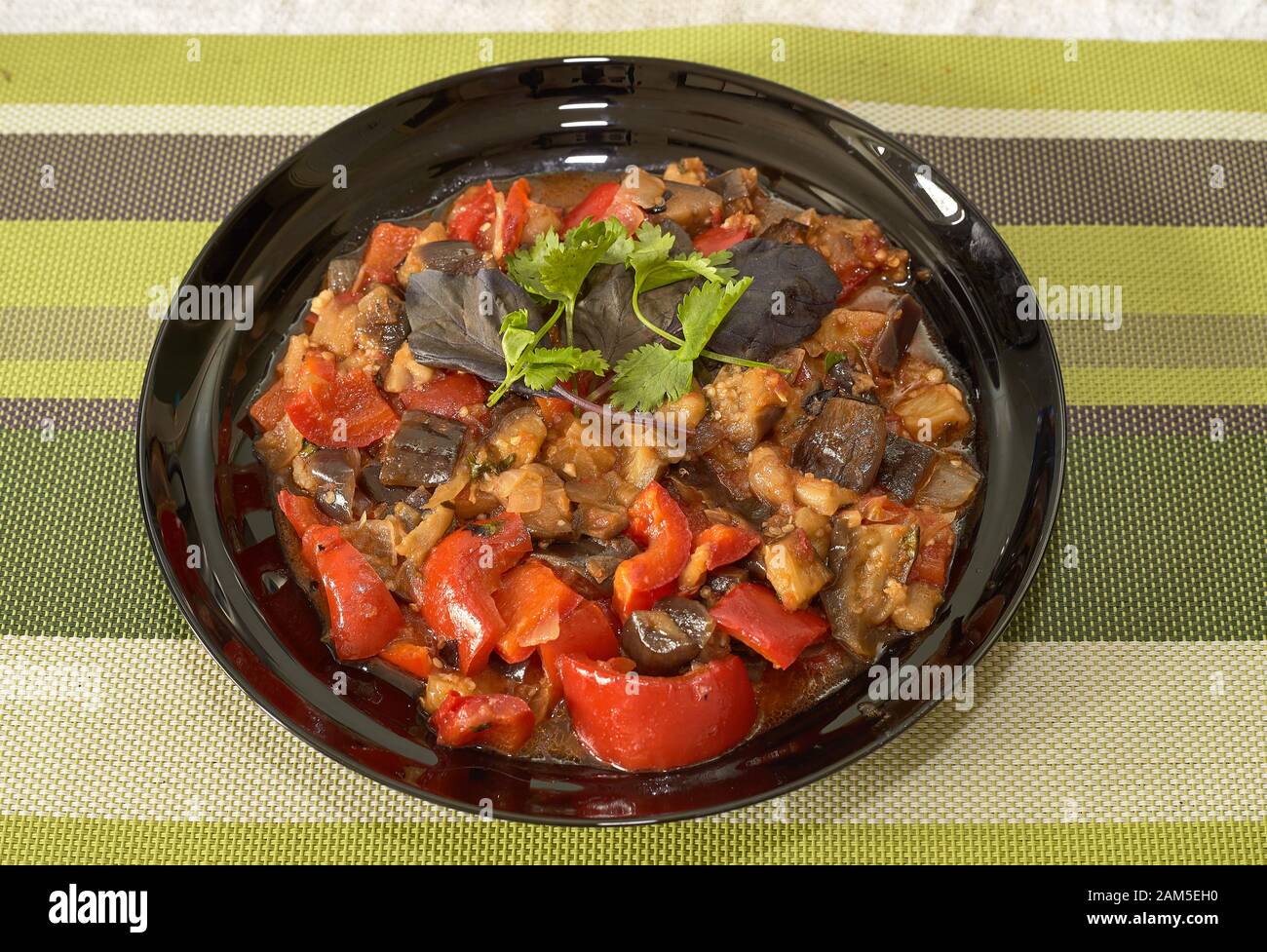 Red pepper with eggplant in its own sauce and parsley leaf on top. Stock Photo