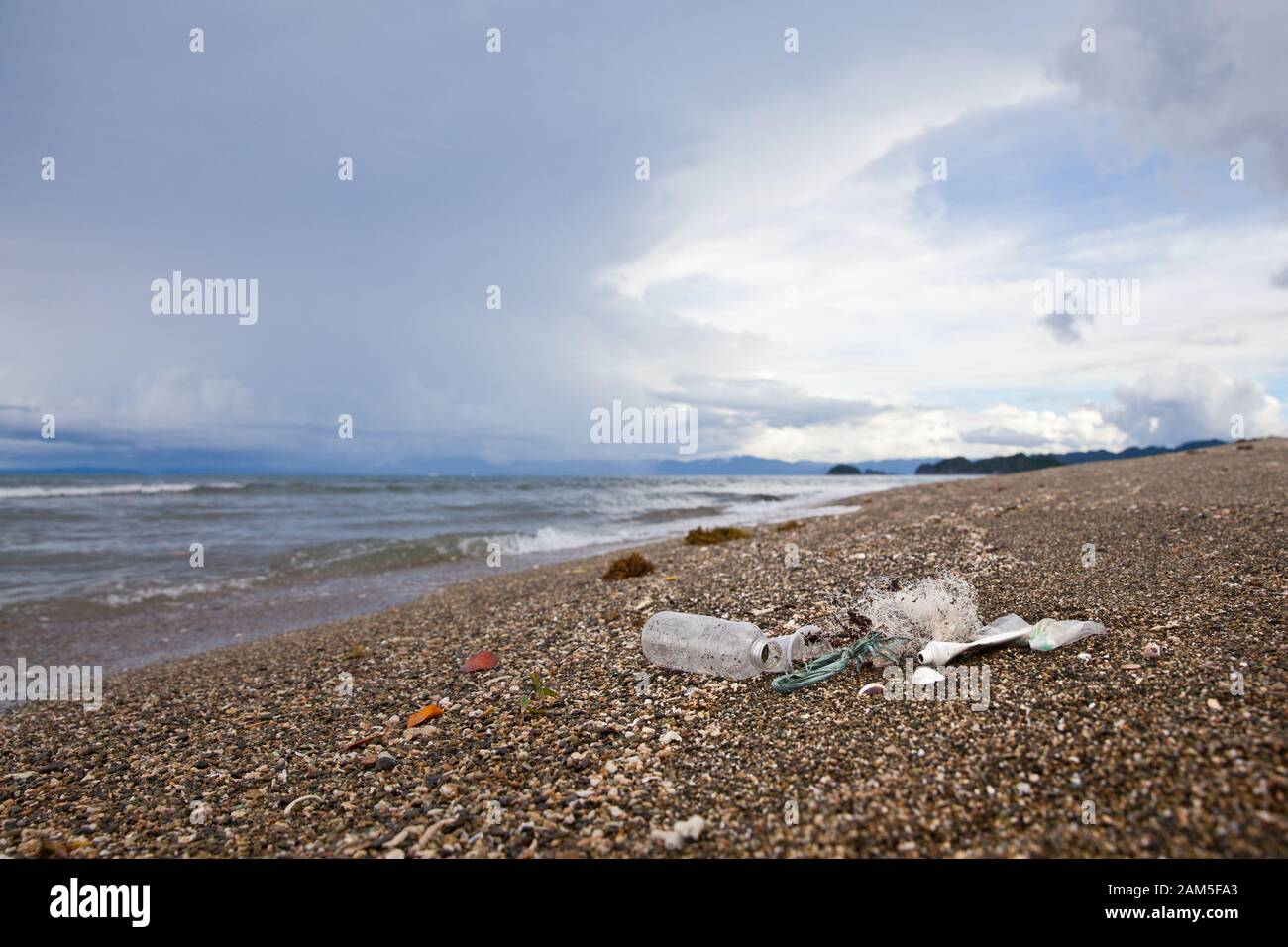 Plastic garbage thrown to the seashore. Plastic waste by the ocean. Stock Photo