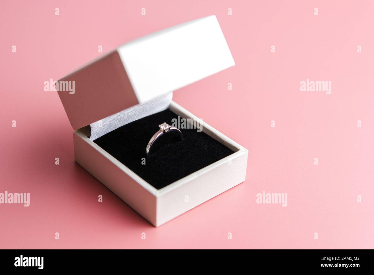 white engagement box with a white ring on a red background Stock Photo