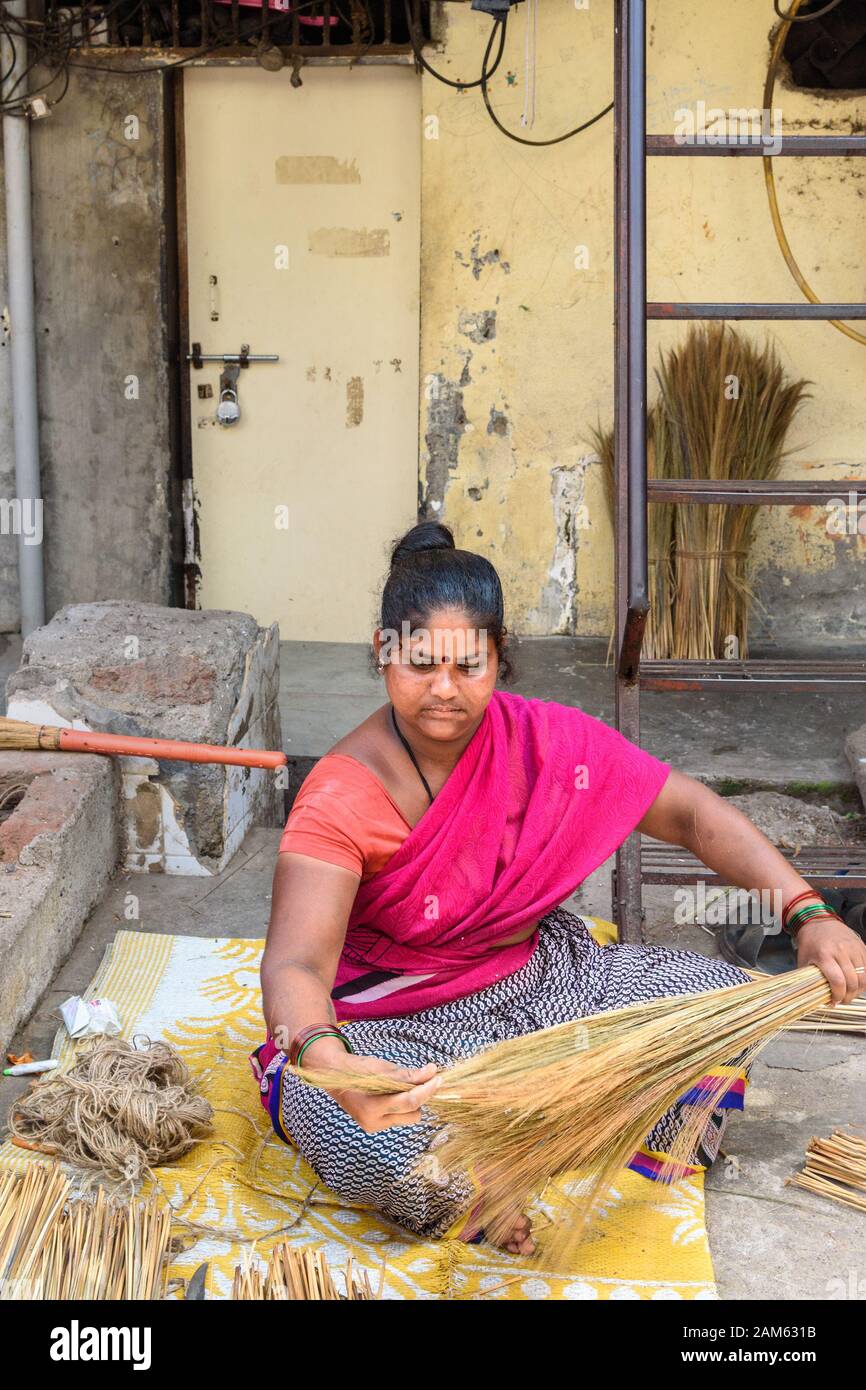 Indian woman making brooms in Dharavi Slum at Mumbai. India Stock Photo