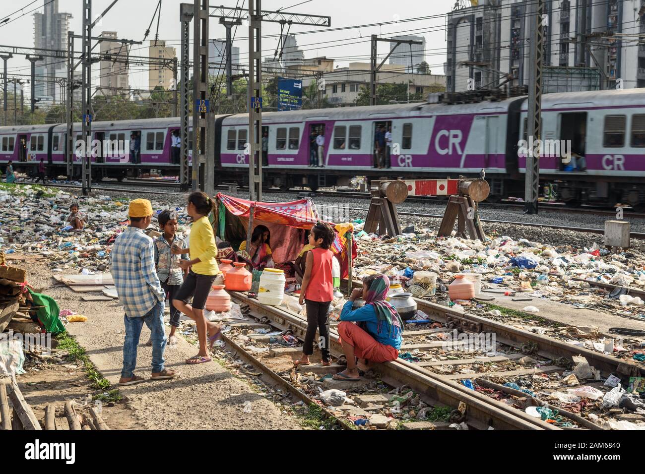 Indian poor people live near Suburban Railway in Dharavi Slum at Mumbai. India Stock Photo