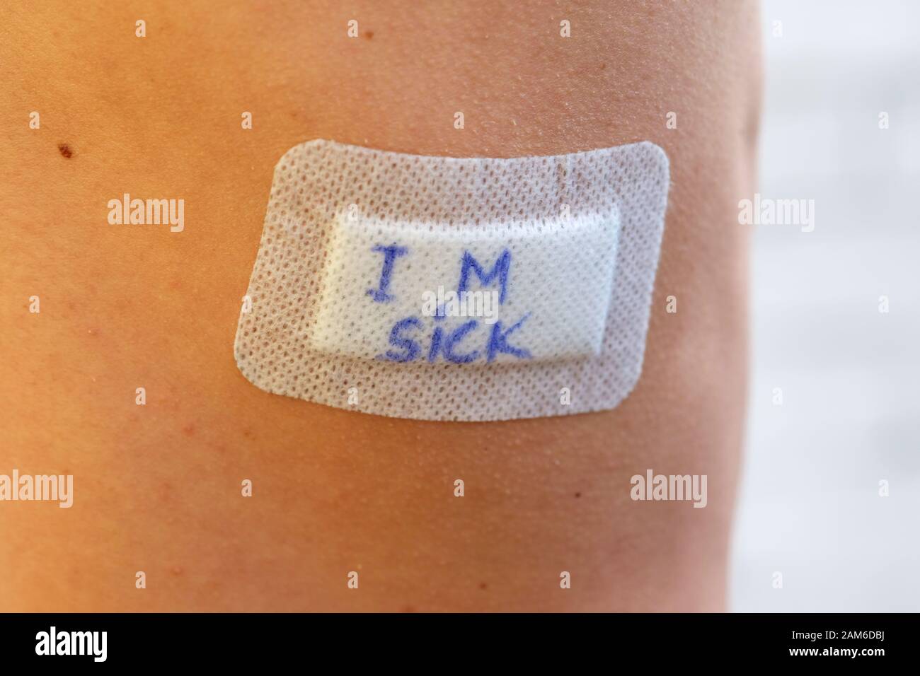 Adhesive plaster on the skin with the words "I'm sick." Female body