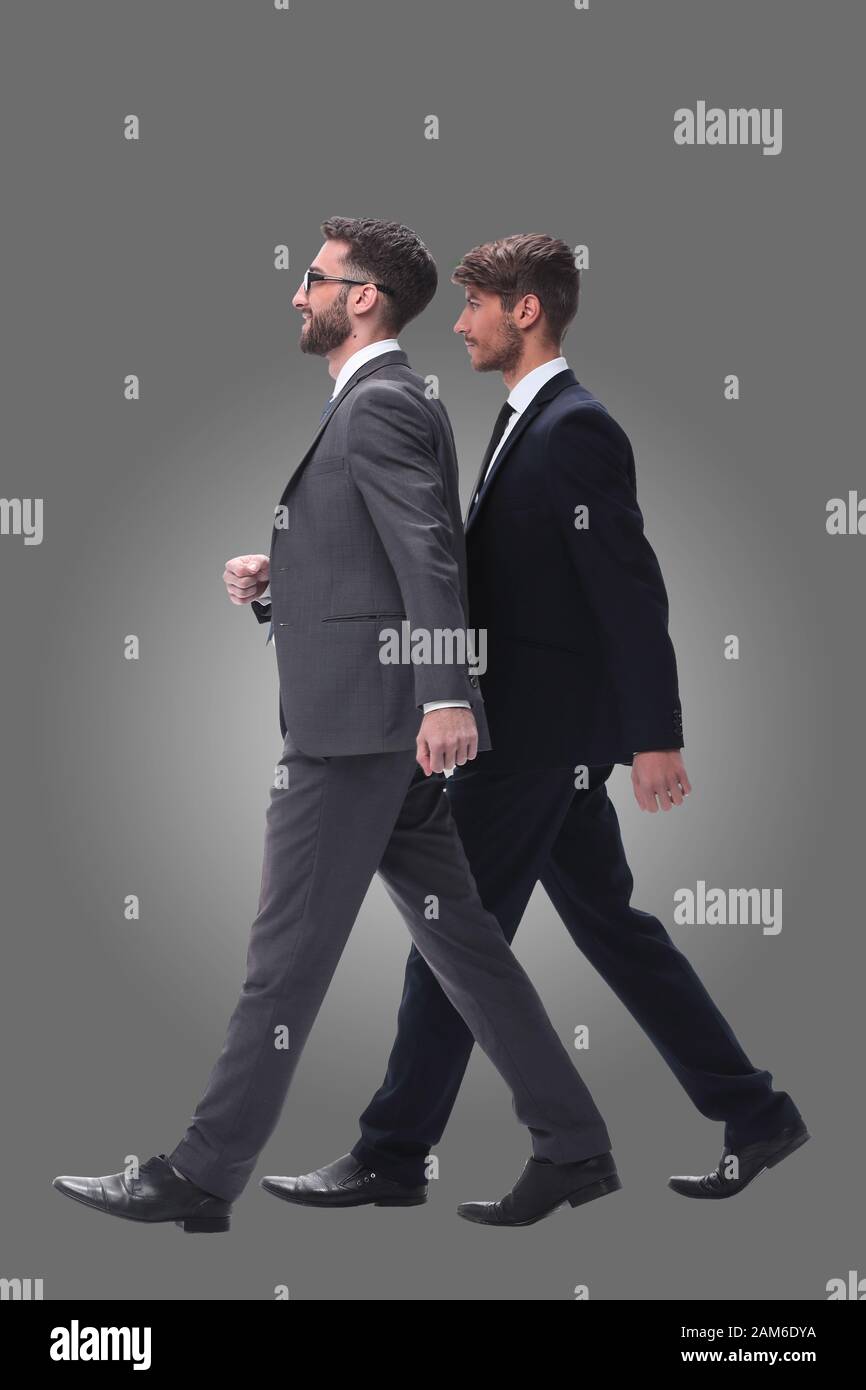 side view. two young businessmen stepping forward Stock Photo - Alamy