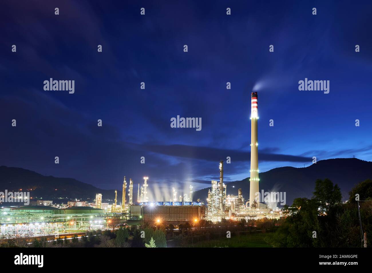 Main tower and chimneys of the Petronor refinery in the municipality Bizkaino of Muskiz, near beach of the Arena, photographed at night, Basque Countr Stock Photo