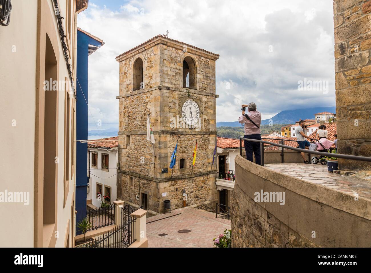 Lastres, Spain. A male photographer looking at the Torre del Reloj (Clock Tower) Stock Photo