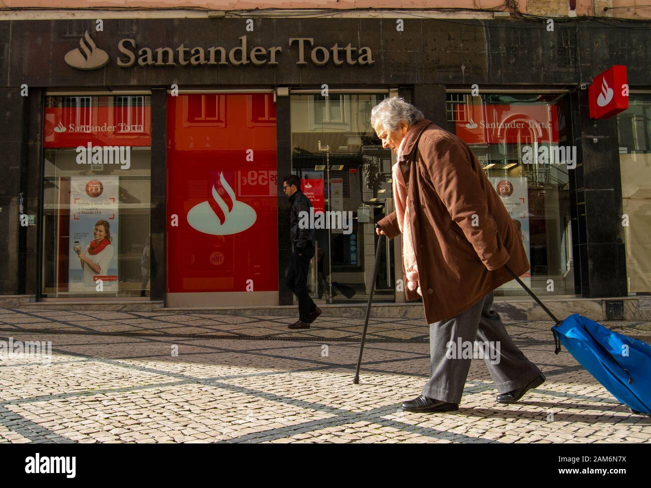 People pass by a branch of the Santander Totta bank in Coimbra Portugal Stock Photo