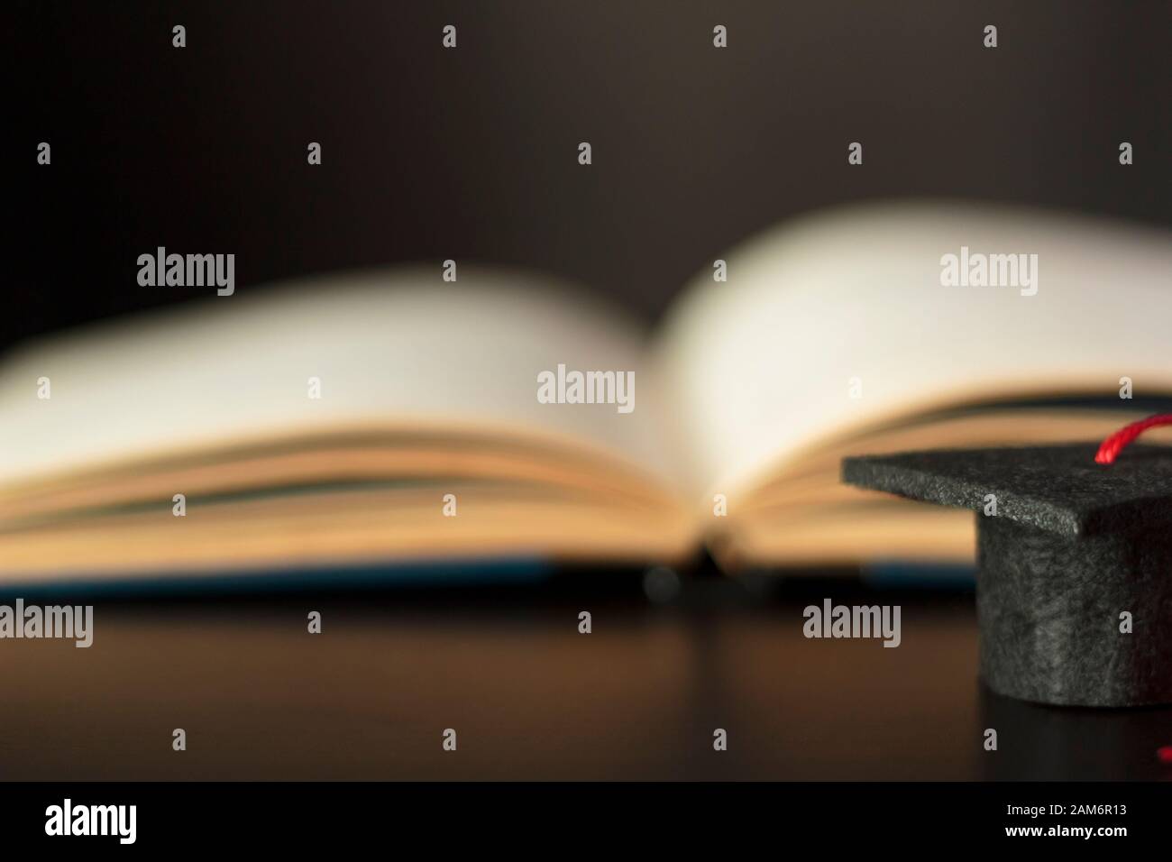 Graduation cap with open book on the background with copy space ...